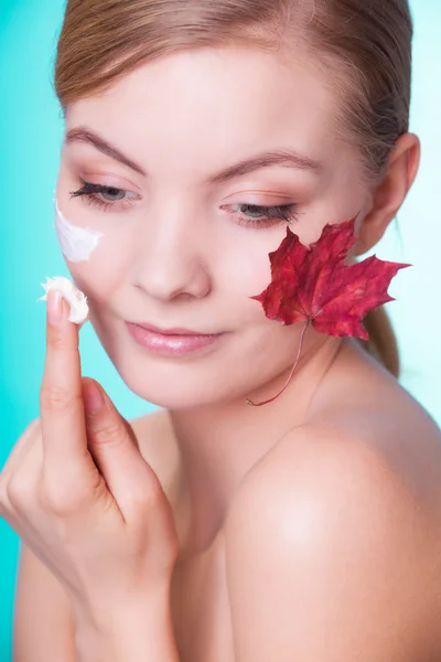 Face of young woman with red maple leaf. — Stock Photo, Image
