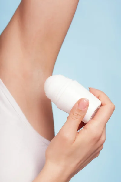 Meisje aanbrengen stok deodorant in oksel. — Stockfoto