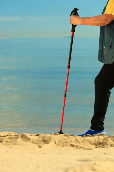 Mulher ativa sênior nórdico andando em uma praia. pernas — Fotografia de Stock