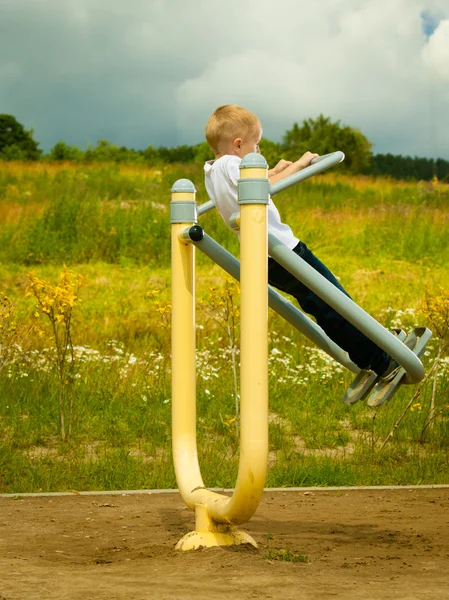 Junge spielen auf Stretchgeräten — Stockfoto