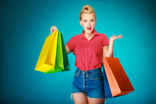 Девушка в пинапе с сумками покупает одежду — стоковое фото