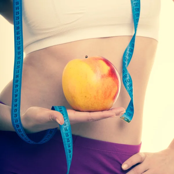 Chica con cinta métrica, manzana de fruta . —  Fotos de Stock