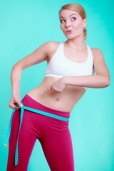 Mujer fitness con cinta métrica midiendo sus lomos —  Fotos de Stock