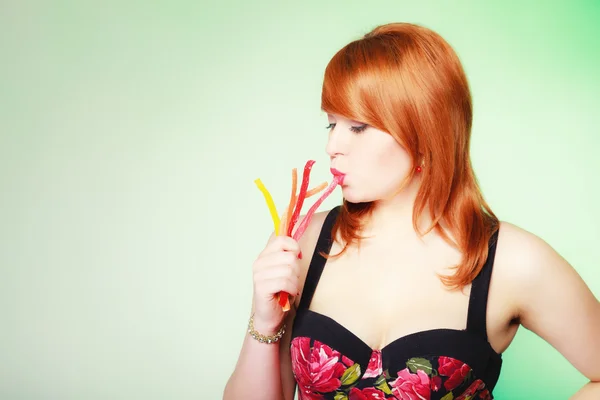 Redhair girl holding sweet food jelly candy on green. — Stock Photo, Image