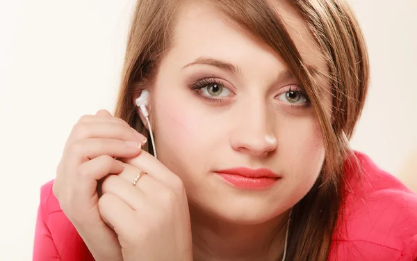 Flicka med vita hörlurar lyssnar på musik — Stockfoto