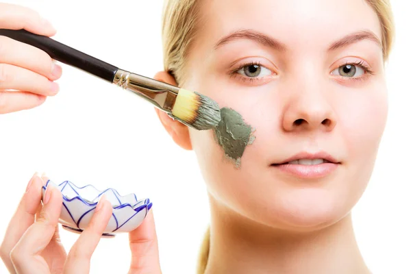 Mujer aplicando mascarilla de barro en la cara . — Foto de Stock