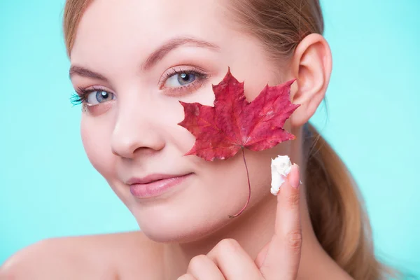 Face of young woman with red maple leaf. — Stock Photo, Image