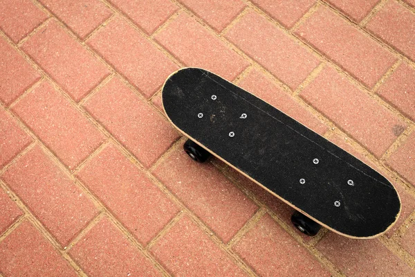 Одинокий скейтборд на бетонном фоне — стоковое фото