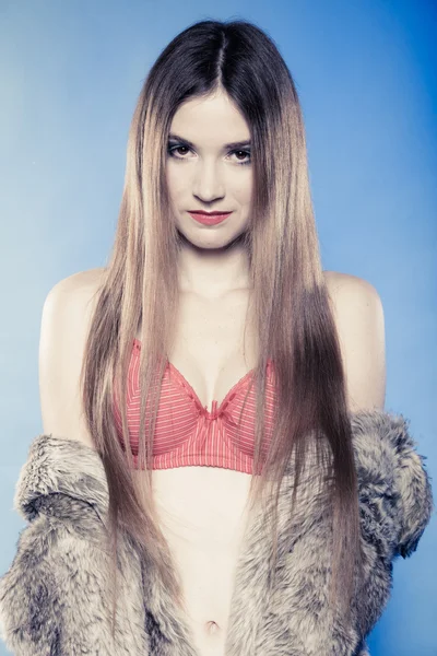 Sexy girl with long hair in red bra underwear and fur coat on blue — Stock Photo, Image