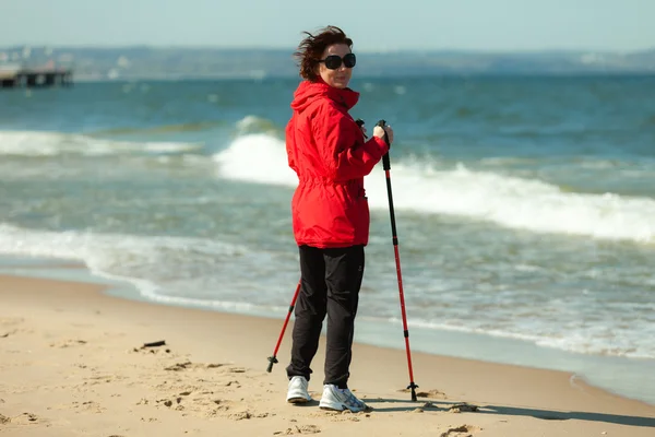 Нордическая ходьба. Женщина, гуляющая по пляжу. — стоковое фото