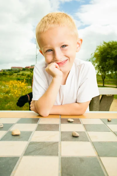 Child playing draughts or checkers — Stock Photo, Image