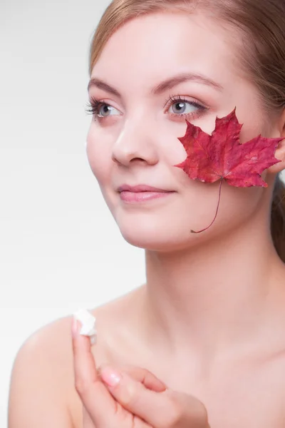 Gezicht van jonge meisje met rood esdoornblad — Stockfoto