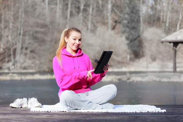 Kobieta za pomocą tabletki na molo — Zdjęcie stockowe