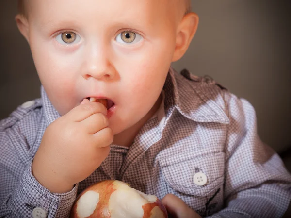 Menino comendo maçã vermelha — Fotografia de Stock