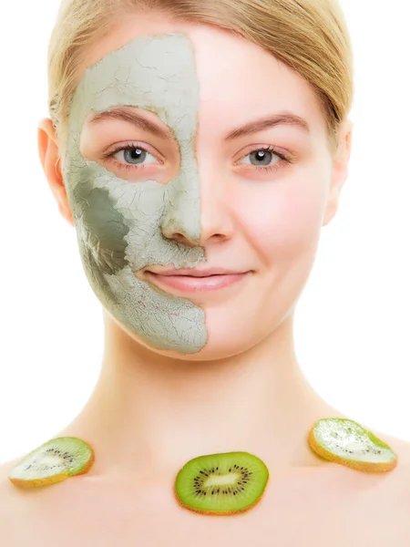 Vrouw in klei masker op het gezicht en kiwi — Stockfoto