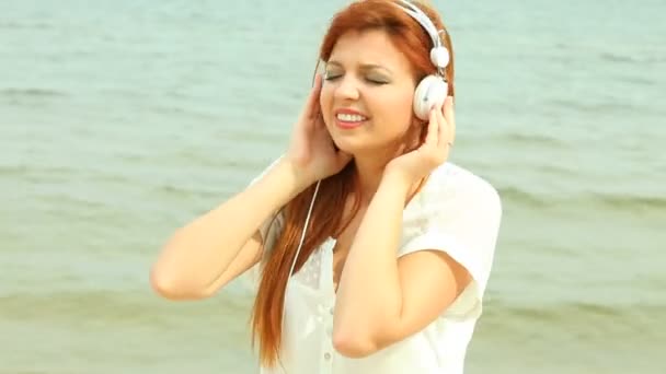 Mujer en la playa escuchando música — Vídeos de Stock