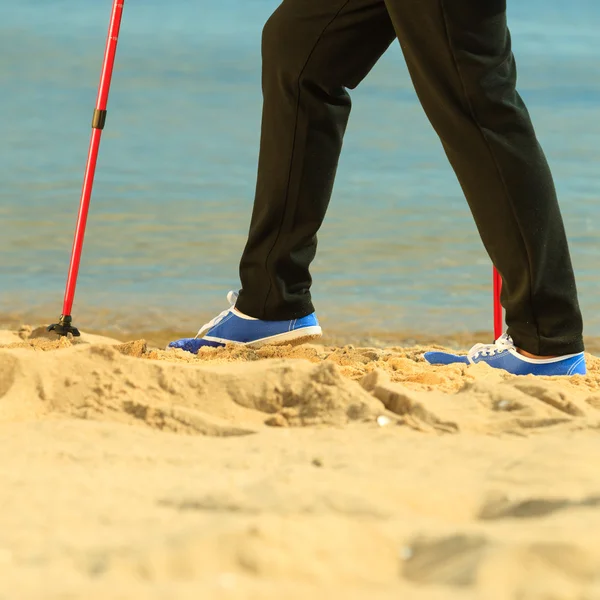 Seniorin beim Nordic Walking am Strand — Stockfoto