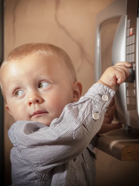 Niño jugando con temporizador de horno de microondas — Foto de Stock