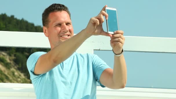 Чоловік фотографує зі смартфоном — стокове відео