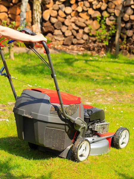 Jardinagem. Cortando gramado verde com cortador de grama vermelho — Fotografia de Stock