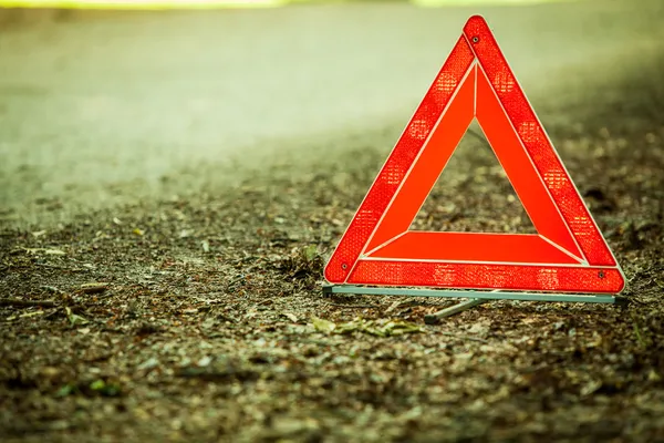 Desglose del coche. Señal roja del triángulo de advertencia en la carretera — Foto de Stock