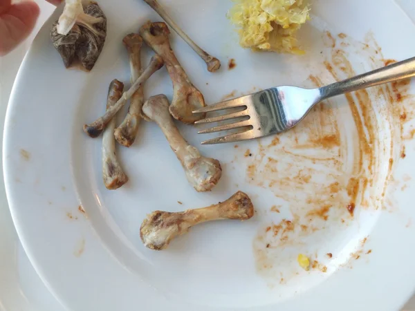 Placa sucia con huesos de carne después de terminar la comida . —  Fotos de Stock