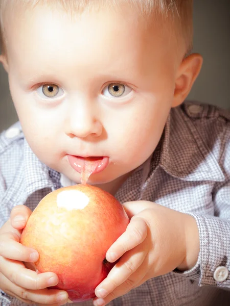 Netter kleiner Junge isst rote Apfelfrüchte — Stockfoto