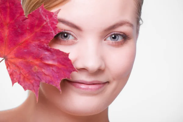 Skin care. Portrait of young woman girl with red maple leaf. — Stock Photo, Image