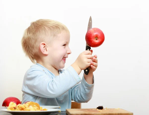 Blond boy child kid preschooler with kitchen knife cutting fruit apple — Stock Photo, Image