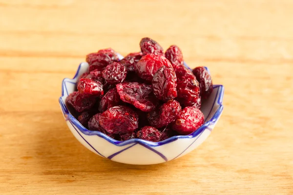 Diet healthy food. Dried cranberries in bowl on wooden table background — Stock Photo, Image