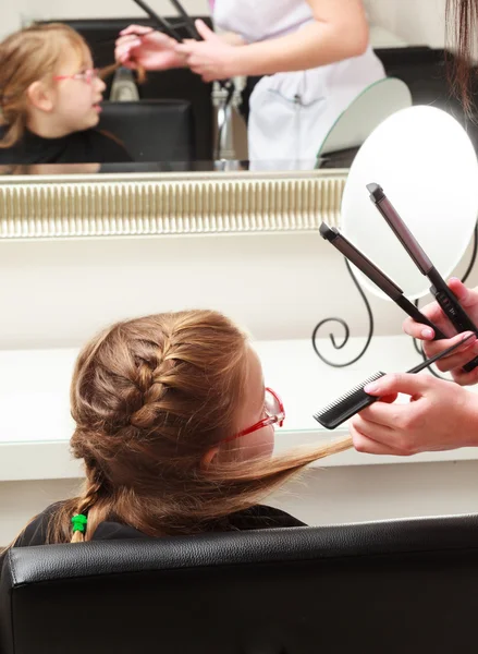 In hair salon. Little girl child sitting by hairdresser combing hair — Stock Photo, Image