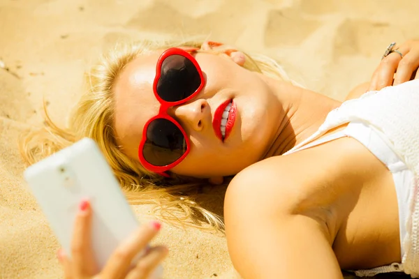 Sahil üstünde hareket eden telefon ile genç kız — Stok fotoğraf