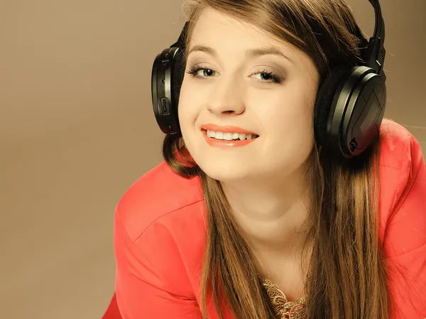 Technologia, muzyka - uśmiechnięta młoda dziewczyna w słuchawkach — Zdjęcie stockowe