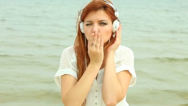 Женщина на пляже слушает музыку — стоковое видео