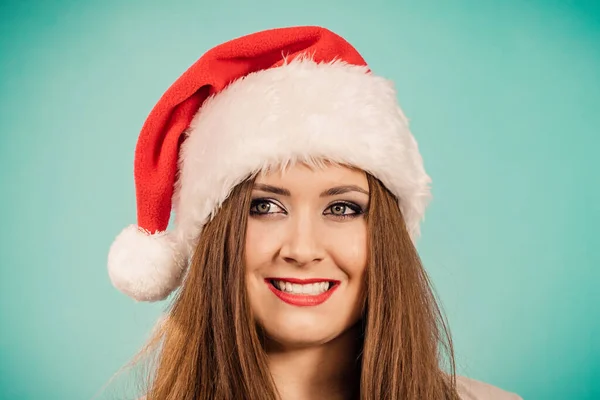 若いですブルネット笑顔女性でクリスマスサンタ帽子 上の青 — ストック写真