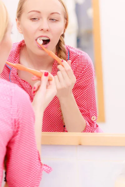 歯を磨く女 鏡を見てバスルームで歯ブラシを持つ少女 口腔衛生 — ストック写真