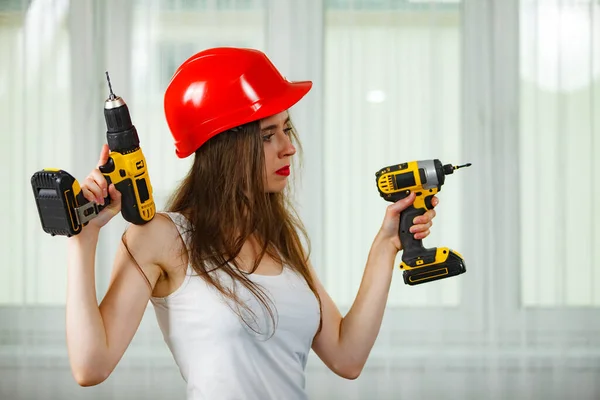 年轻妇女在家里工作时使用动力驱动和螺丝刀 在公寓改造中工作的女孩建筑 维修和翻新 — 图库照片