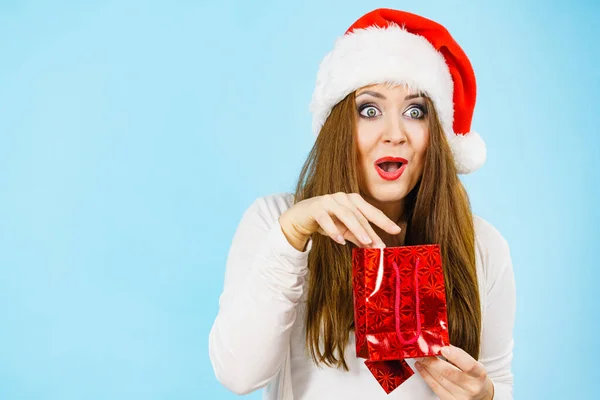 Woman Wearing Santa Claus Hat Holds Red Gift Bag Surprised — Stock Photo, Image