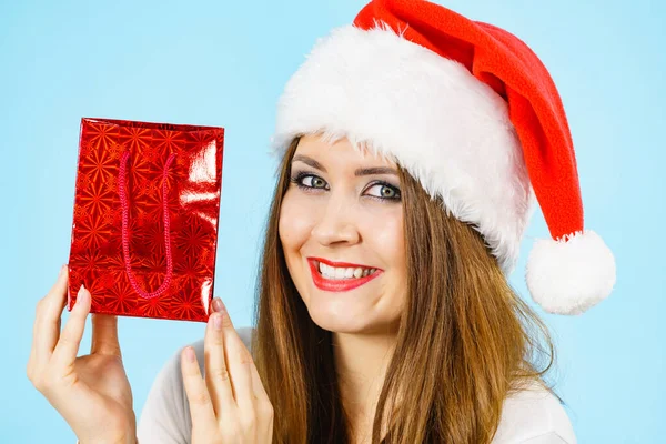미소짓는 여자는 크리스마스 선물을 기꺼이 드립니다 가방을 클라우스 모자를 파란색 — 스톡 사진