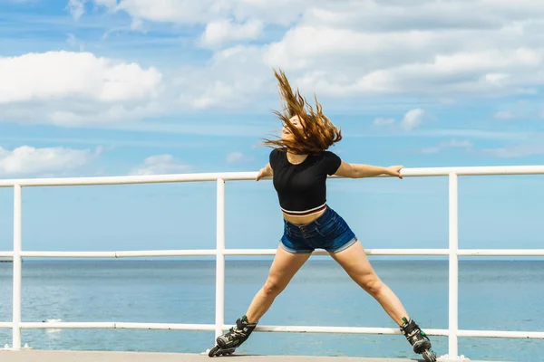 乗車後にリラックスしたローラースケートを身に着けている魅力的な若い女性 海の海岸で夏の時間の間に楽しんでいる女性にフィット — ストック写真