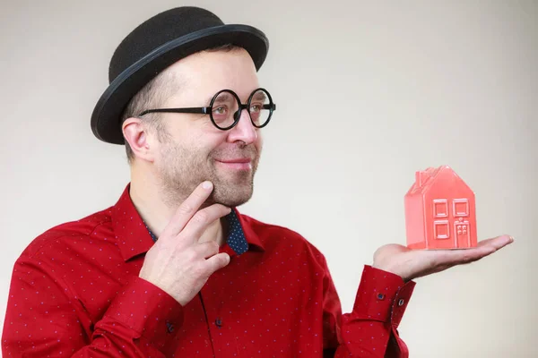 Dospělý Muž Legračním Klobouku Brýlích Drží Malý Červený Model Domu — Stock fotografie