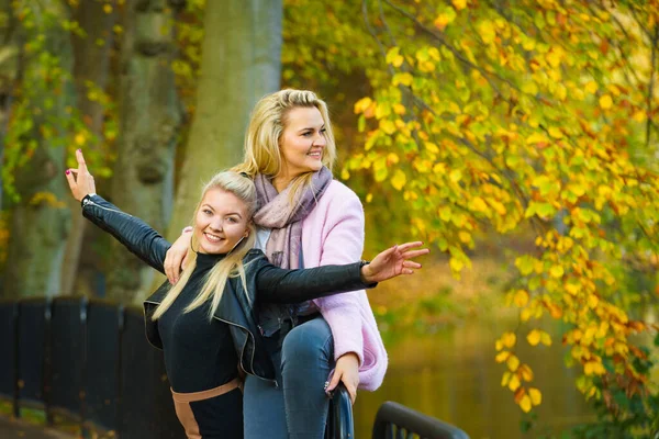 秋の公園を歩くファッショナブルな衣装を着た二人のブロンド女性 — ストック写真