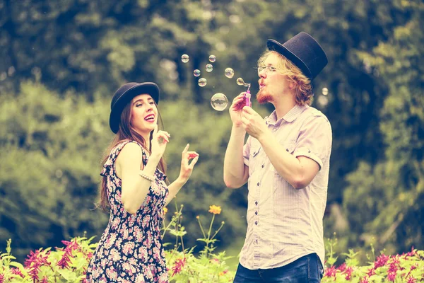 Feliz Divertido Hipster Pareja Jugando Juntos Soplando Jabón Burbujas Aire — Foto de Stock