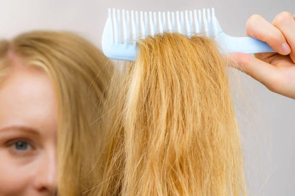 Mulher Loira Com Pente Escovando Seu Cabelo Muito Longo Bagunçado — Fotografia de Stock