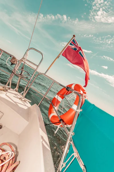 前面帆船上的红旗 英国国旗和救生圈 — 图库照片