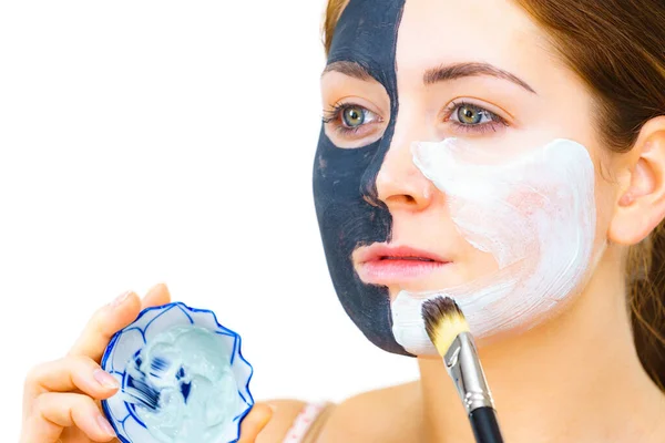 白い泥を肌をきれいにするために適用する半分の顔に粘土のカルボ黒マスクを持つ女性 女の子は油性の肌の世話をする 美容方法だ スキンケア — ストック写真