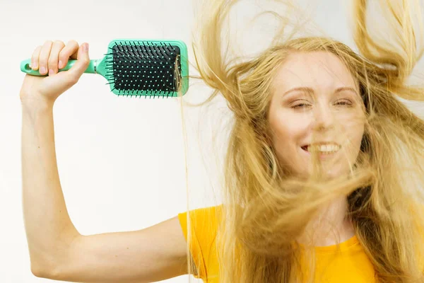 Blondýnka Dlouhé Rozcuchané Vlasy Drží Velký Kartáč Rozmotává Kartáčuje Vlasy — Stock fotografie