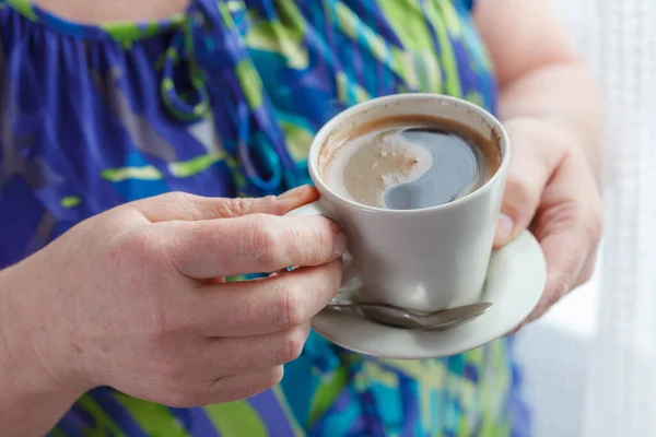 老年妇女在家里喝酒喝些热饮料 高级退休女性控股杯咖啡在他们手中 — 图库照片
