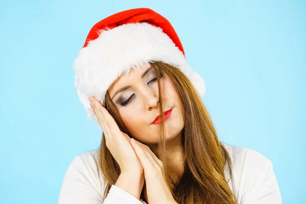 彼女の手で睡眠ジェスチャーをジェスチャーサンタの帽子を身に着けている疲れた女性 大人の女性は 昼寝をする準備ができて眠いです クリスマスタイム — ストック写真