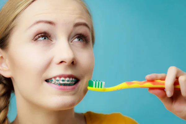Woman with Blue Braces, brushing teeth